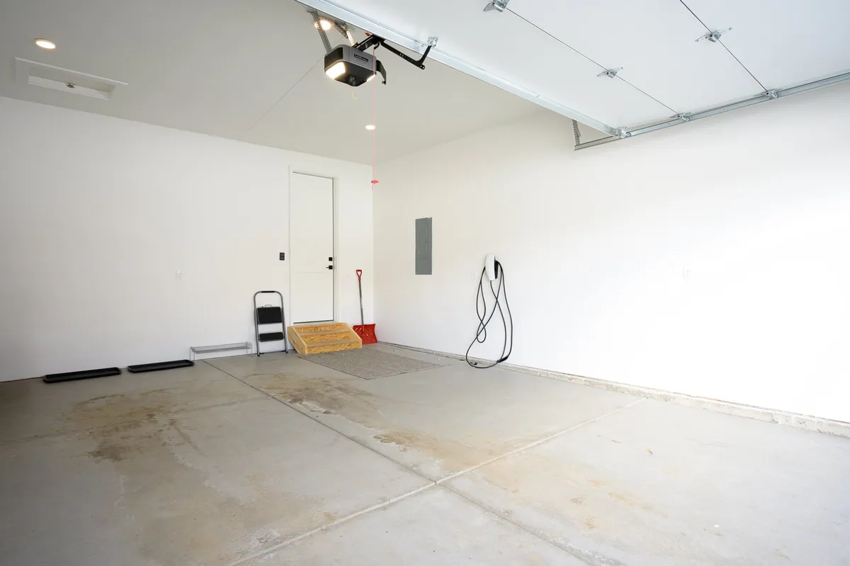 A practical, clean view of the attached garage’s interior, featuring a garage door, clean concrete floor, and direct access to the home. The space is functional and uncluttered, suitable for gear storage or vehicle parking.